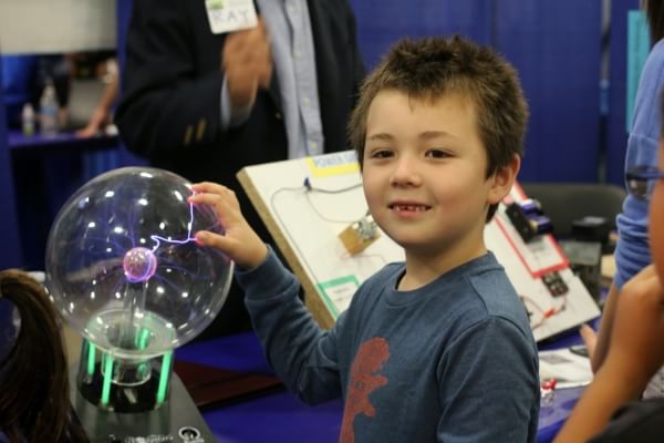 High Tech Fair Attendee touches a plasma ball